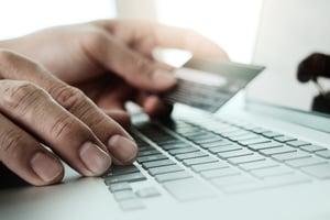 close up of hands using laptop and holding credit card  as Online shopping concept